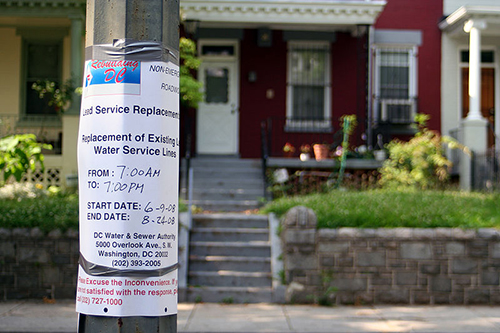 A paper notice taped to a light pole warning people that high levels of lead are detected in the water