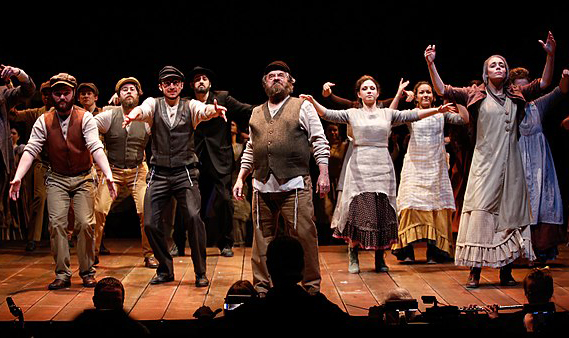Group of performers on stage in old timey clothes