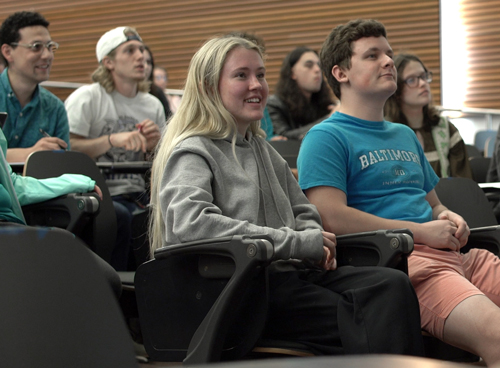 A group of smiling students in a lecture hall