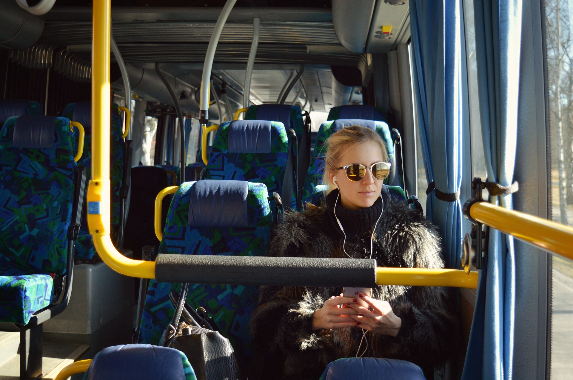 A student on a bus listening to a podcast