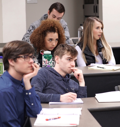 A group of students concentrating on a speaker