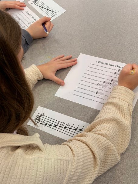 A student completing a written reflection or reading log assignment