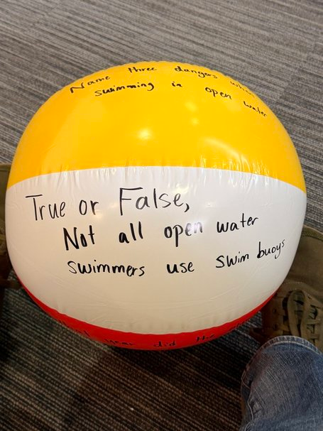 A beach ball covered in true or false discussion prompts, used as an interactive teaching tool